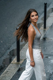 Top corto halter de fit ajustado, escote v cruzado con cortes, plisados decorativos y lazo amarrable posterior.