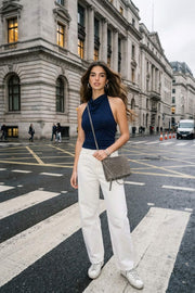 Top corto de cuello halter fluido, sin mangas, fit ajustado y escote en espalda.