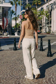 Top corto de cuello halter fluido, sin mangas, fit ajustado y escote en espalda.
