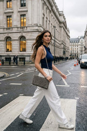 Top corto de cuello halter fluido, sin mangas, fit ajustado y escote en espalda.