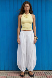 Top corto de cuello halter fluido, sin mangas, fit ajustado y escote en espalda.