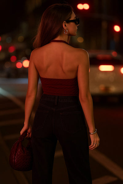 Top corto halter de fit ajustado, cuello fluido, sin mangas, elástico posterior y escote en espalda. Detalle de textura en tejido.