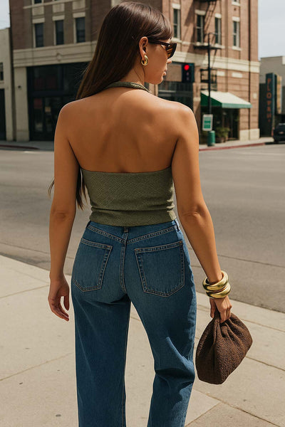 Top corto halter de fit ajustado, cuello fluido, sin mangas, elástico posterior y escote en espalda. Detalle de textura en tejido.