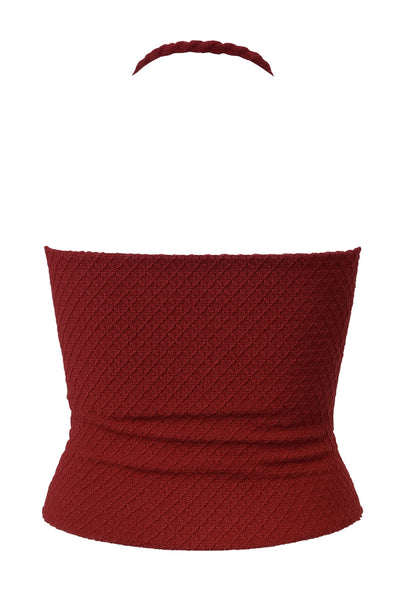 Top corto halter de fit ajustado, cuello fluido, sin mangas, elástico posterior y escote en espalda. Detalle de textura en tejido.