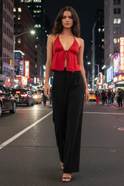 Top corto satinado de escote v con lazo amarrable frontal, rib elástico en espalda, tirantes halter con lazo amarrable posterior y abertura frontal en bajo. Detalle de peplum olanes en bajo.