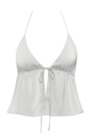 Top corto satinado de escote v con lazo amarrable frontal, rib elástico en espalda, tirantes halter con lazo amarrable posterior y abertura frontal en bajo. Detalle de peplum olanes en bajo.
