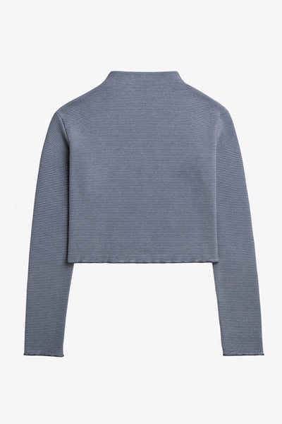 Top de manga larga con hombro caído, cuello mock seguido, fit recto, textura en tejido, detalle de rib en borde de bajo y puños.