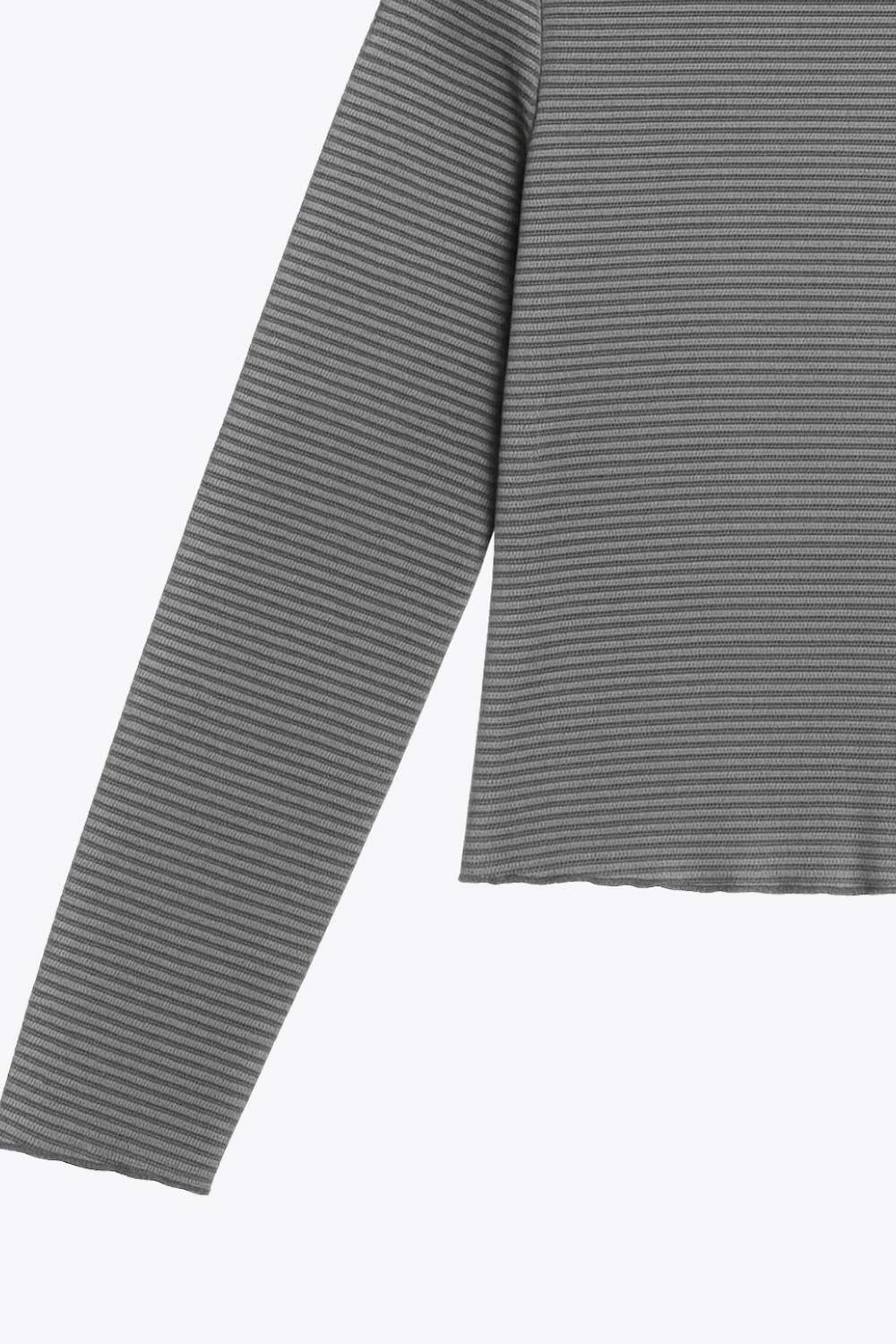 Top de manga larga con hombro caído, cuello mock seguido, fit recto, textura en tejido, detalle de rib en borde de bajo y puños.