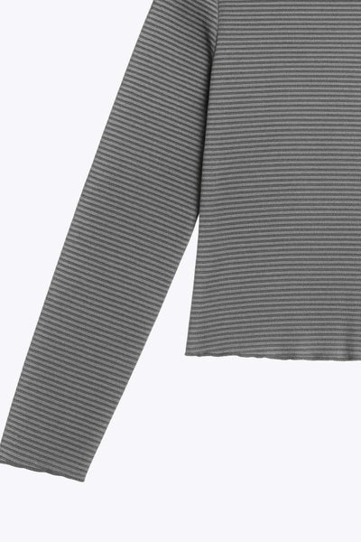 Top de manga larga con hombro caído, cuello mock seguido, fit recto, textura en tejido, detalle de rib en borde de bajo y puños.