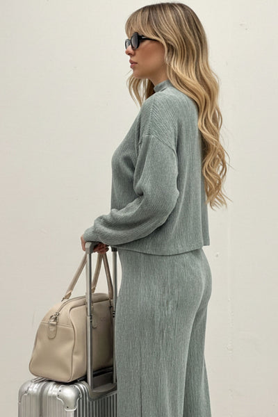 Top de manga larga con hombro caído, cuello mock seguido, fit recto y textura en tejido.