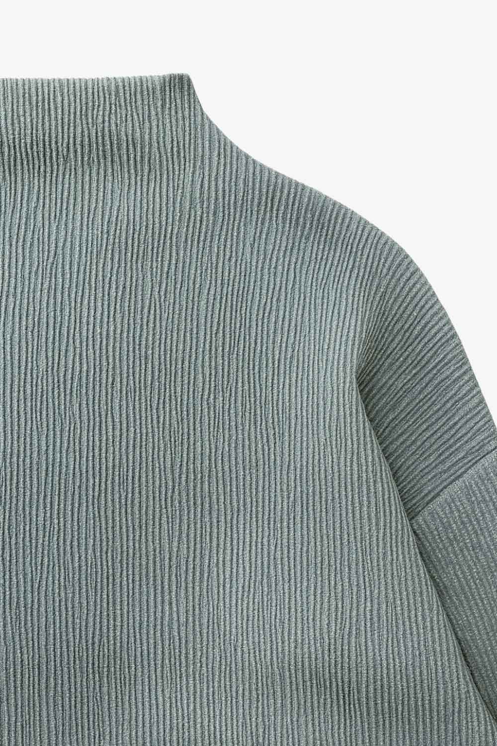 Top de manga larga con hombro caído, cuello mock seguido, fit recto y textura en tejido.