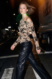 Blusa de mesh con estampado floral, fit recto, manga larga y cuello diagonal asimétrico con hombro descubierto.