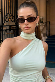 Top satinado asimétrico, de fit ajustado, detalles plisados laterales y en hombro, sin mangas, un hombro, escote diagonal y choker con plisados. Cierre posterior con botón y ojal.