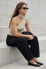 Top satinado asimétrico, de fit ajustado, detalles plisados laterales y en hombro, sin mangas, un hombro, escote diagonal y choker con plisados. Cierre posterior con botón y ojal.