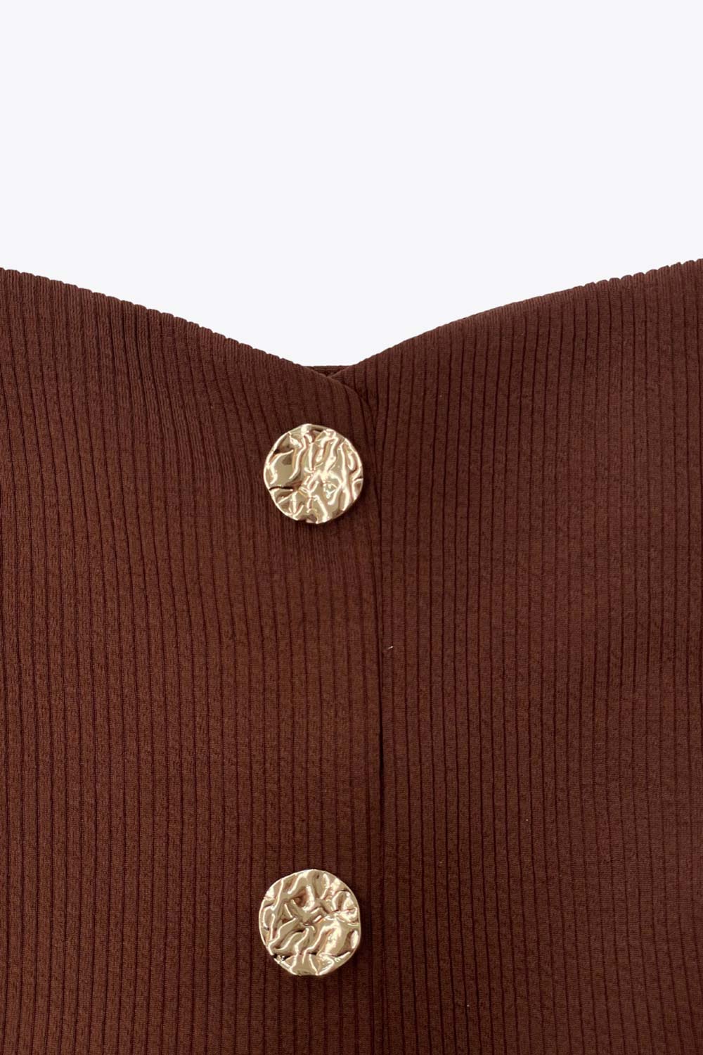 Top canalé de fit ajustado, sin mangas, escote cuadrado, cortes frontales y peplum con olanes en bajo. Cierre frontal con hilera de botones en contraste.