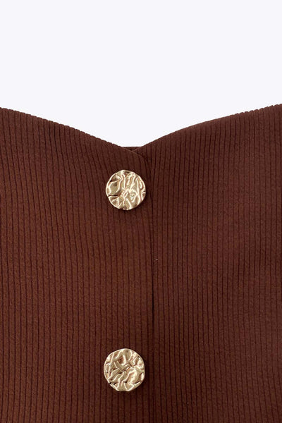 Top canalé de fit ajustado, sin mangas, escote cuadrado, cortes frontales y peplum con olanes en bajo. Cierre frontal con hilera de botones en contraste.