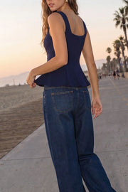 Top de fit ajustado, sin mangas, escote cuadrado, cortes frontales y peplum con olanes en bajo. Cierre frontal con hilera de botones en contraste.