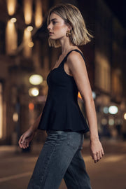 Top de tirantes, fit ajustado, escote corazón, costuras frontales y peplum con olanes en cintura.