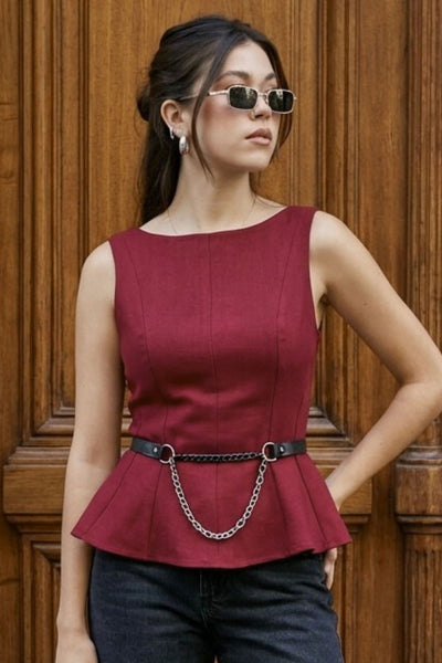 Top de fit ajustado, sin mangas, cuello barco, cortes frontales y peplum con olanes en bajo.