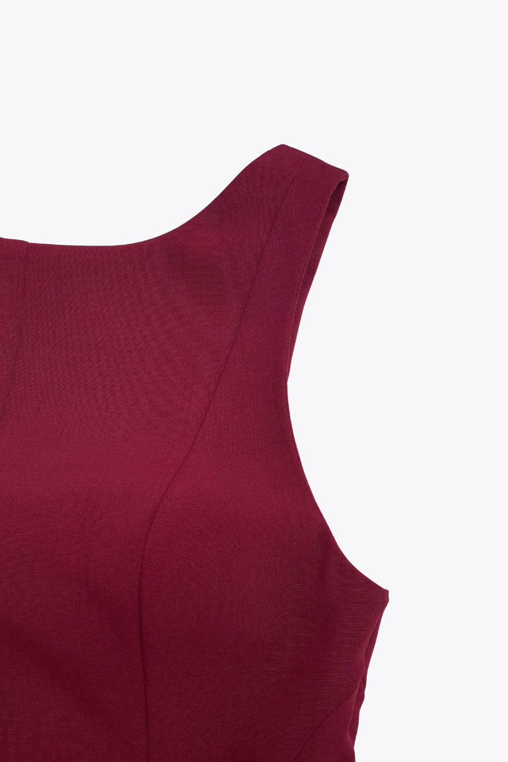 Top de fit ajustado, sin mangas, cuello barco, cortes frontales y peplum con olanes en bajo.