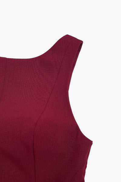 Top de fit ajustado, sin mangas, cuello barco, cortes frontales y peplum con olanes en bajo.