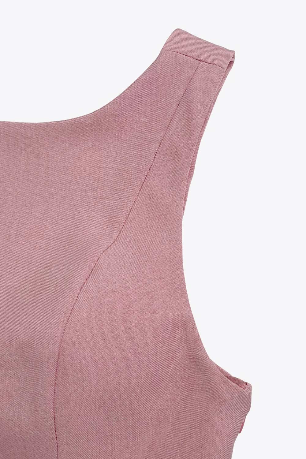 Top de fit ajustado, sin mangas, cuello barco, cortes frontales y peplum con olanes en bajo.