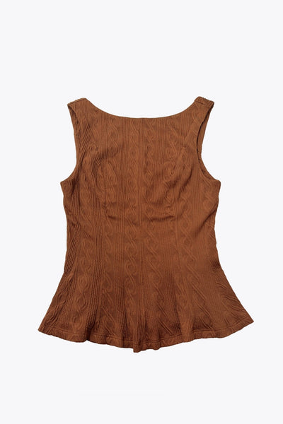 Top corto de peplum con olanes, cuello barco, escote en espalda, sin mangas, cortes frontales y detalle de textura en tejido.