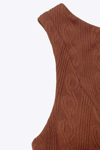 Top corto de peplum con olanes, cuello barco, escote en espalda, sin mangas, cortes frontales y detalle de textura en tejido.