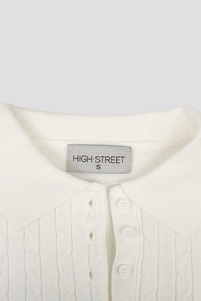 Top canalé de punto, fit ajustado, manga larga, cuello polo con botones, rib en bajo y puños. y escote v con cuello polo. Detalle de textura en tejido.