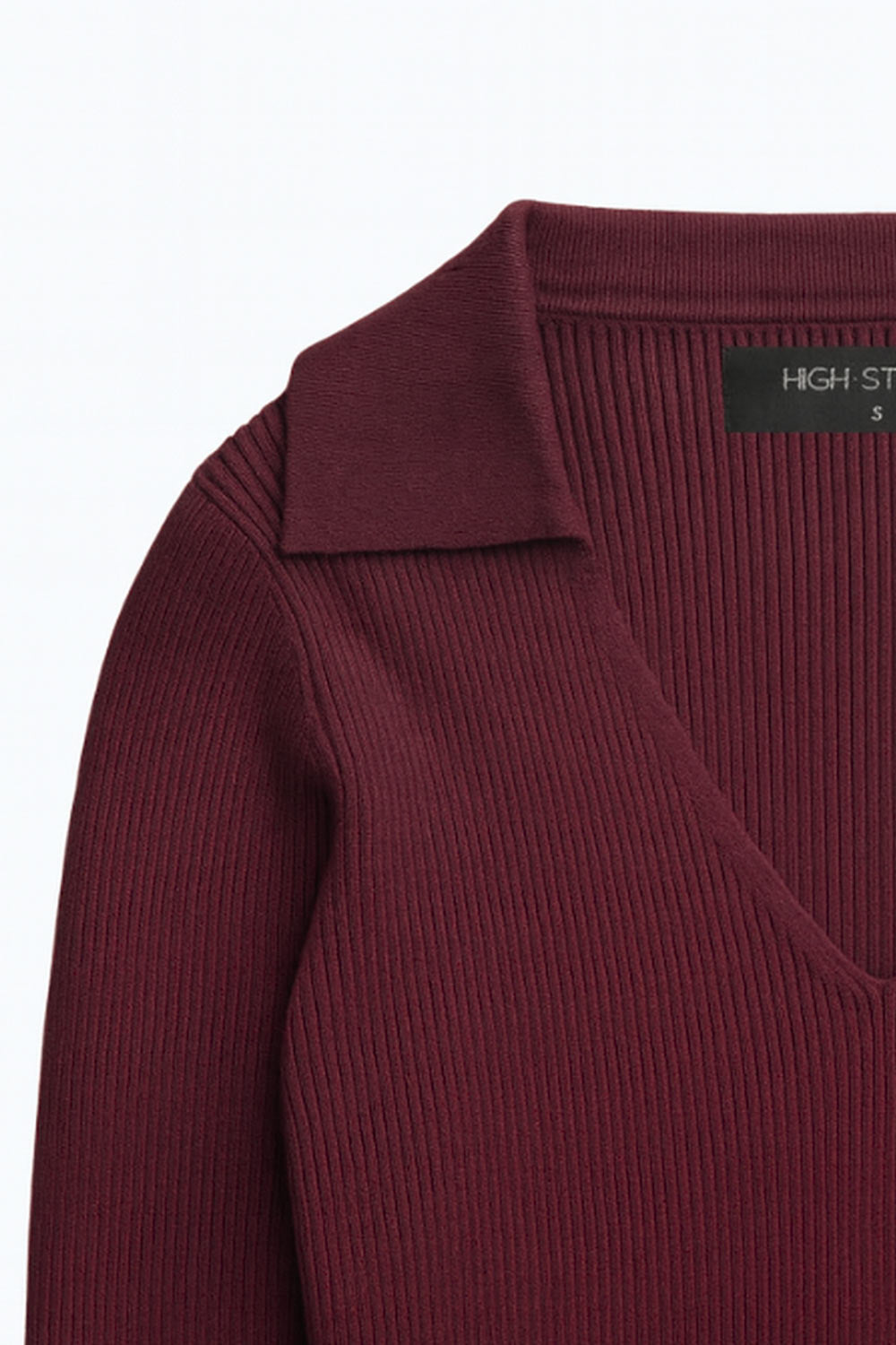 Top canalé de punto, fit ajustado, manga corta y escote v con cuello polo.