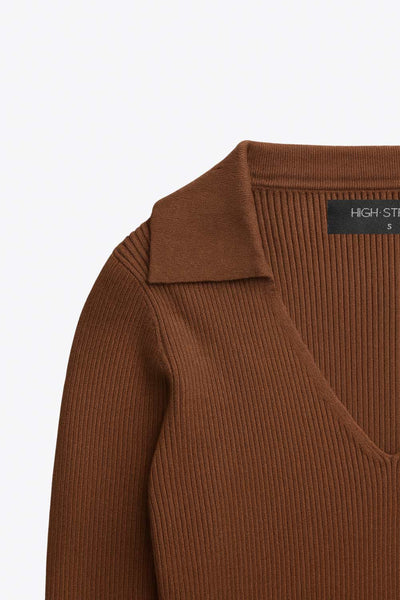 Top canalé de punto, fit ajustado, manga corta y escote v con cuello polo.