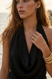 Top de cuello halter con escote fluido, sin mangas y escote v en espalda.