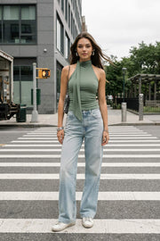 Top de fit ajustado, sin mangas, escote en espalda, cuello halter con plisados y nudo amarrable.
