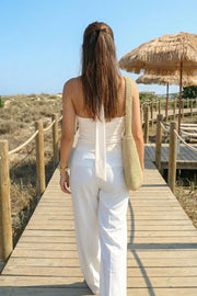 Top de fit ajustado, sin mangas, escote en espalda, cuello halter con plisados y nudo amarrable.