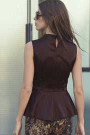 Blusa de fit ajustado, cuello alto fluido, sin mangas, peplum con olanes en bajo, cierre posterior con botón y ojal.