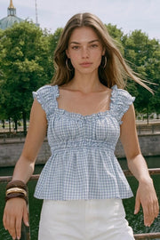 Top corto de estampado cuadros, escote v redondeado y manga corta con rib elástico y olanes en borde, elástico en cintura y peplum con olanes en bajo.