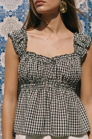 Top corto de estampado cuadros, escote v redondeado y manga corta con rib elástico y olanes en borde, elástico en cintura y peplum con olanes en bajo.