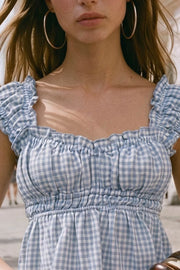 Top corto de estampado cuadros, escote v redondeado y manga corta con rib elástico y olanes en borde, elástico en cintura y peplum con olanes en bajo.