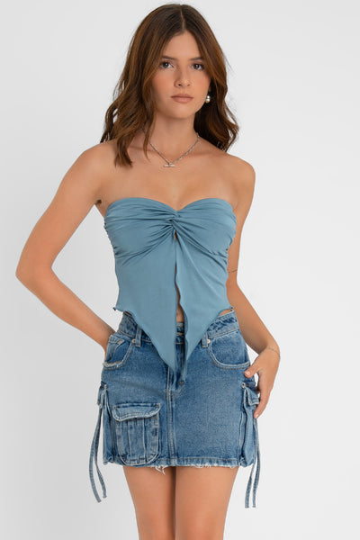 Top strapless satinado de escote corazón con nudo, plisados decorativos en costados y abertura frontal con bajo asimétrico. Rib rizado en borde de bajo.