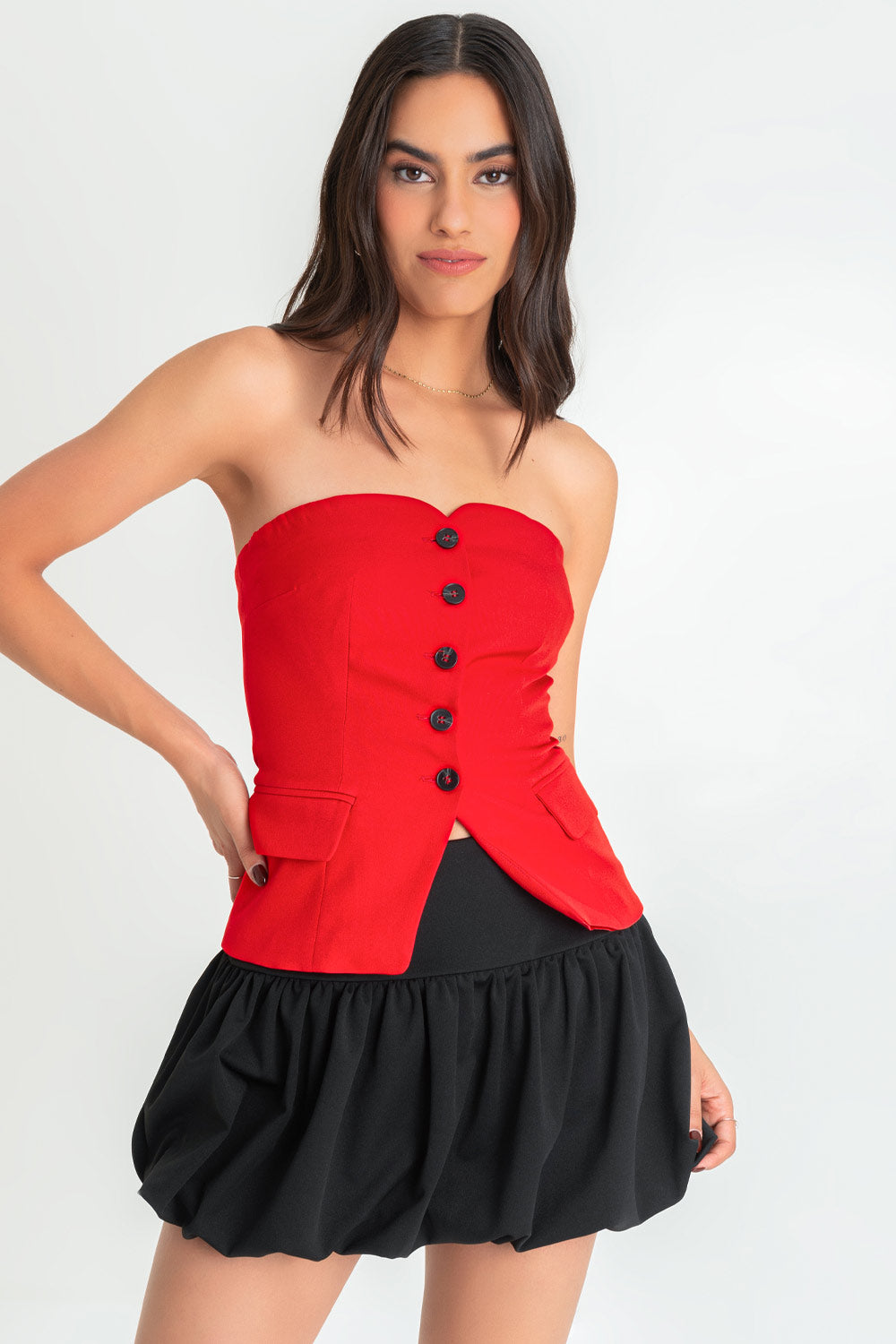 Top strapless de fit ajustado, escote corazón, bolsillos frontales decorativos con cartera, bajo curveado frontal y cierre con hilera de botones en contraste.