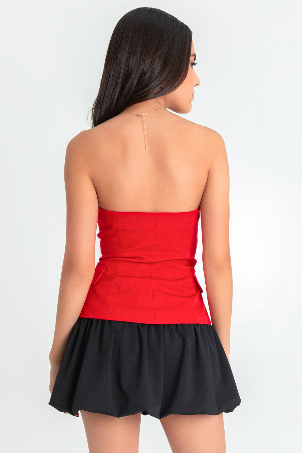 Top strapless de fit ajustado, escote corazón, bolsillos frontales decorativos con cartera, bajo curveado frontal y cierre con hilera de botones en contraste.