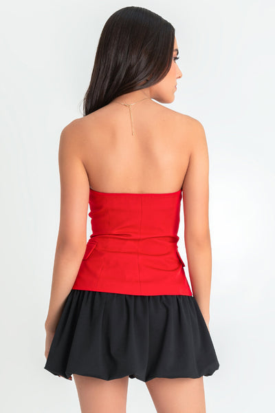 Top strapless de fit ajustado, escote corazón, bolsillos frontales decorativos con cartera, bajo curveado frontal y cierre con hilera de botones en contraste.