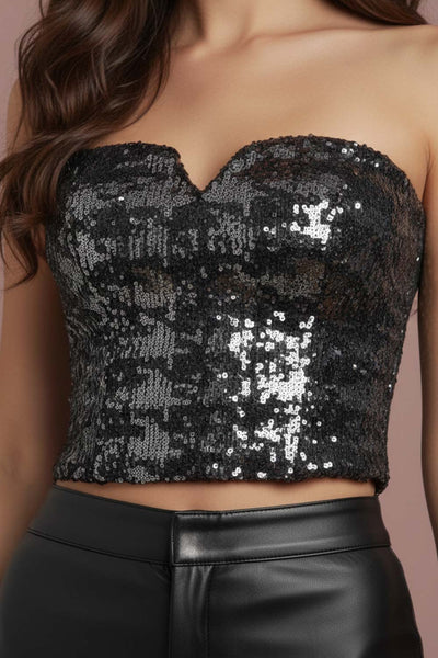 Crop top strapless de lentejuelas, estampado pata de gallo, escote corazón con detalle en v, cortes frontales y cierre posterior con cremallera visible en contraste.