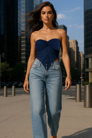 Top strapless satinado de escote corazón con nudo, plisados decorativos en costados y abertura frontal con bajo asimétrico. Rib rizado en borde de bajo.