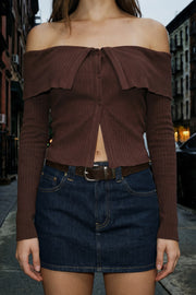 Top corto de punto canalé, fit ajustado, hombros descubiertos, escote recto con doblez en borde, manga larga y cierre frontal con hilera de botones.