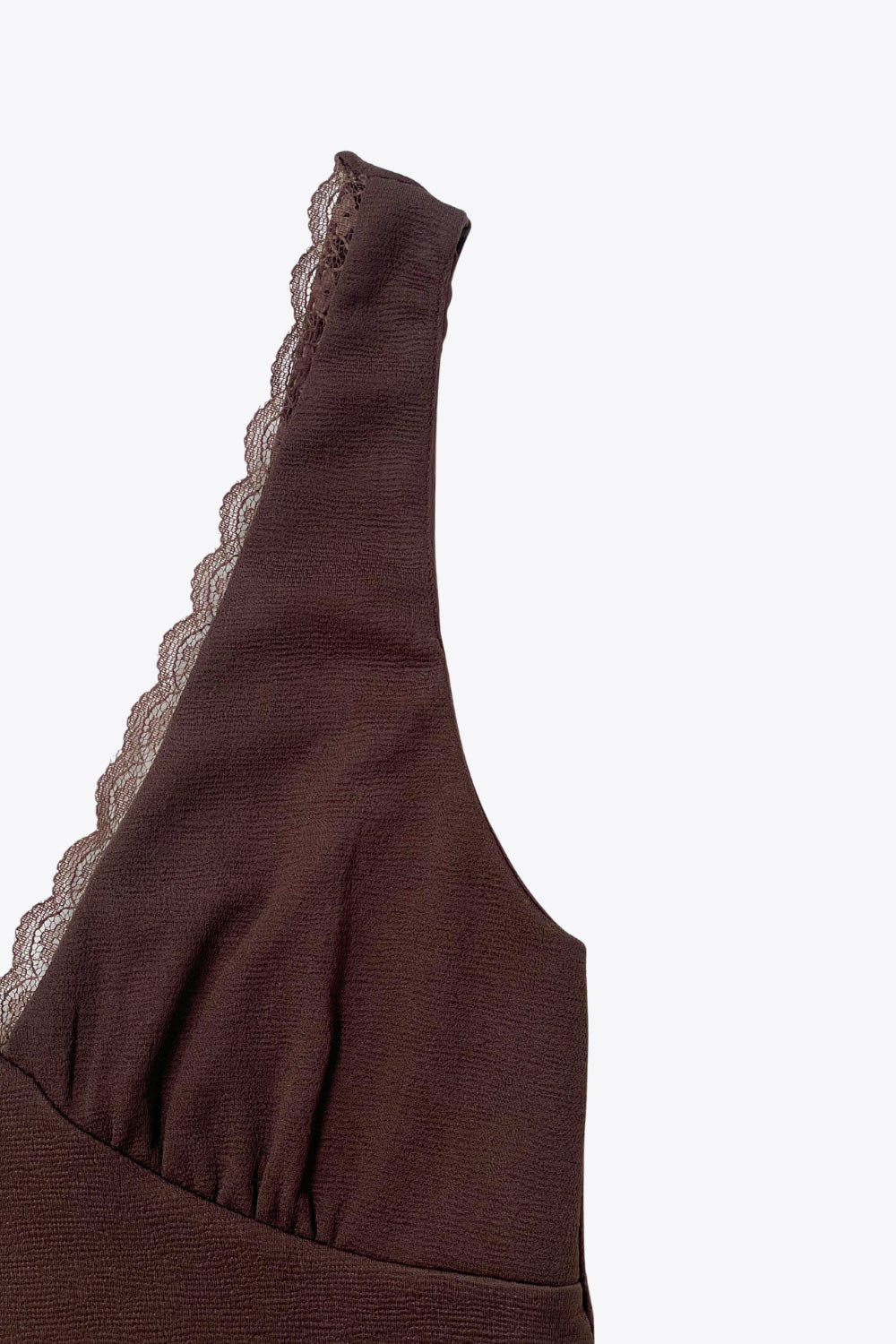 Top de fit ajustado, escote v con encaje en bordes, cortes frontales decorativos con plisados, sin mangas y detalle de textura en tejido.