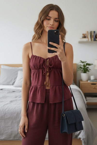 Top de lino, tirantes delgados ajustables, corte en a, capas con olanes en bajo, escote v redondeado con plisados y cut out, abertura frontal y cierre con lazos amarrables. Detalle de fruncido en espalda y detalle decorativo en lazos.