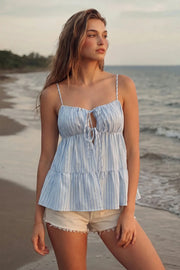 Top de estampado rayas, tirantes delgados ajustables, corte en a, capas con olanes en bajo, escote redondeado con plisados y cut out, abertura frontal y cierre con lazos amarrables. Detalle de fruncido en espalda.