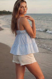 Top de estampado rayas, tirantes delgados ajustables, corte en a, capas con olanes en bajo, escote redondeado con plisados y cut out, abertura frontal y cierre con lazos amarrables. Detalle de fruncido en espalda.