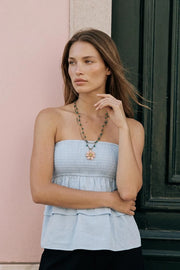 Top strapless de fit ajustado, escote recto con fruncido y peplum con capas de olanes en bajo.
